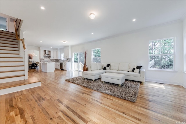 living room featuring light wood-type flooring and ornamental molding