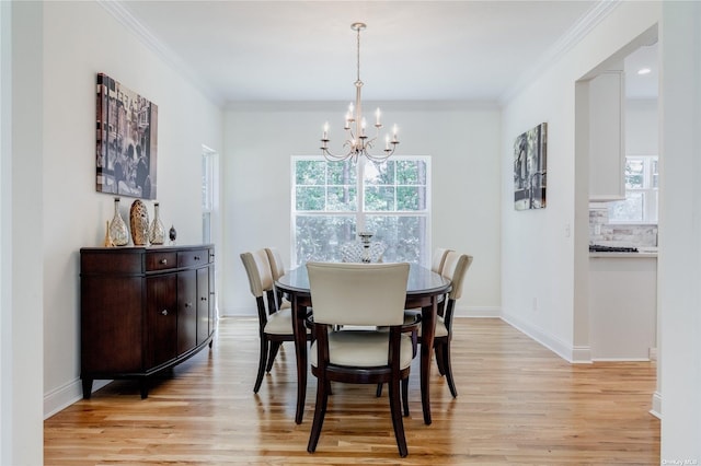 dining room featuring light hardwood / wood-style floors, crown molding, a wealth of natural light, and an inviting chandelier