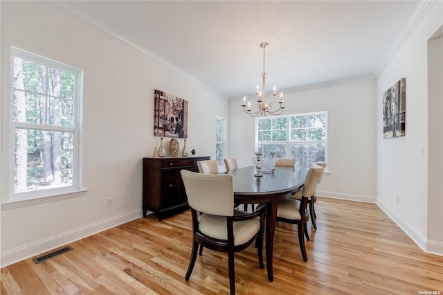 dining space featuring a healthy amount of sunlight, light wood-type flooring, and ornamental molding