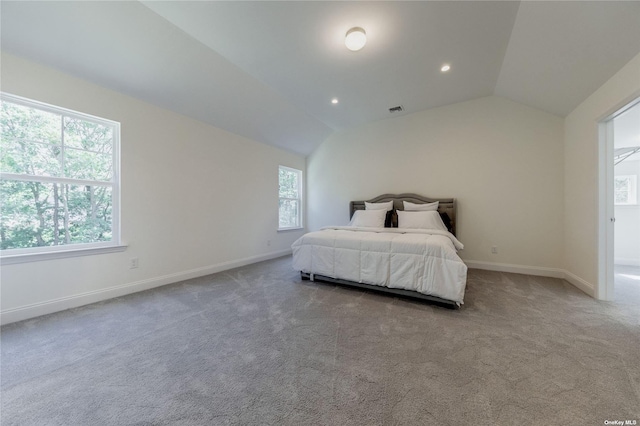 carpeted bedroom featuring multiple windows and vaulted ceiling