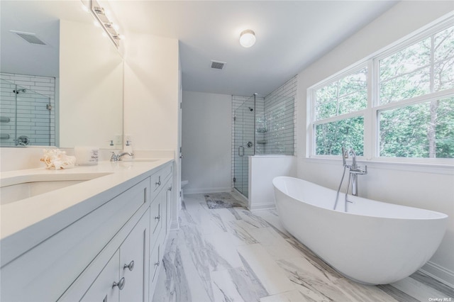 bathroom with vanity and shower with separate bathtub