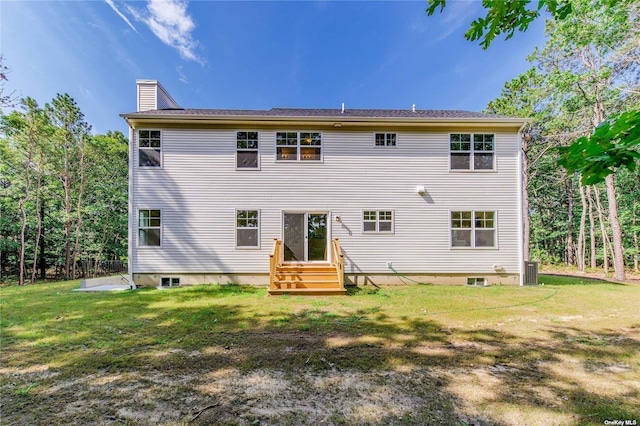 rear view of property featuring a yard and central AC unit