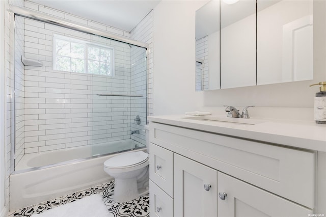 full bathroom featuring tile patterned floors, vanity, bath / shower combo with glass door, and toilet