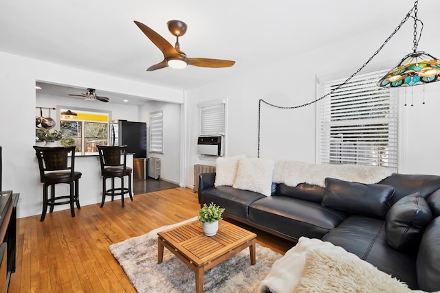 living room featuring radiator heating unit, hardwood / wood-style floors, and ceiling fan