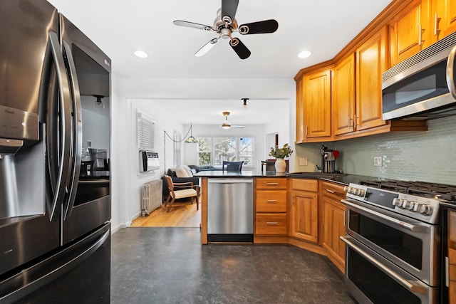 kitchen with kitchen peninsula, radiator heating unit, ceiling fan, backsplash, and stainless steel appliances