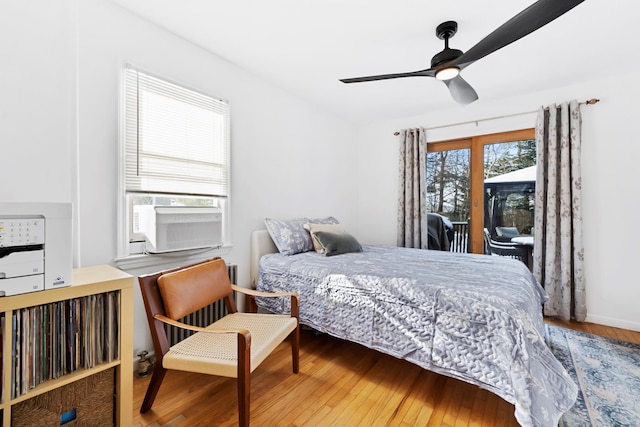 bedroom with ceiling fan, cooling unit, hardwood / wood-style floors, and multiple windows