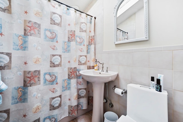 bathroom featuring sink, toilet, tile walls, and a shower with shower curtain