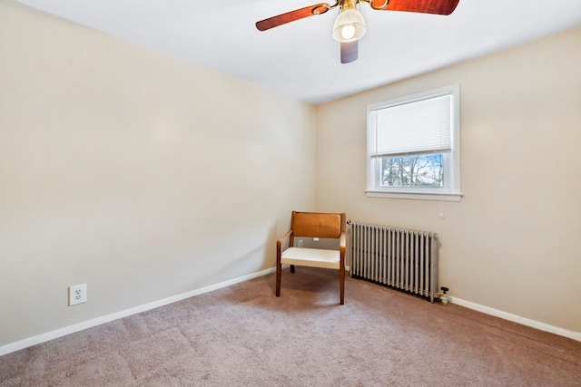 living area with ceiling fan, radiator heating unit, and light carpet