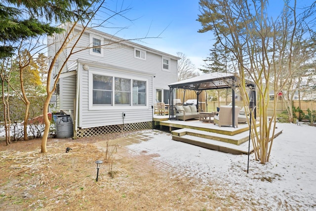 back of property with an outdoor living space and a gazebo