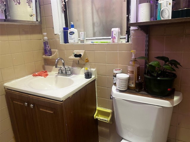 bathroom with vanity, toilet, tile walls, and backsplash