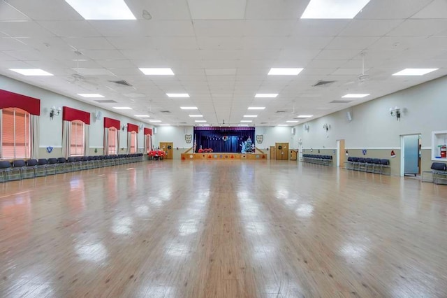 interior space with a paneled ceiling and hardwood / wood-style flooring