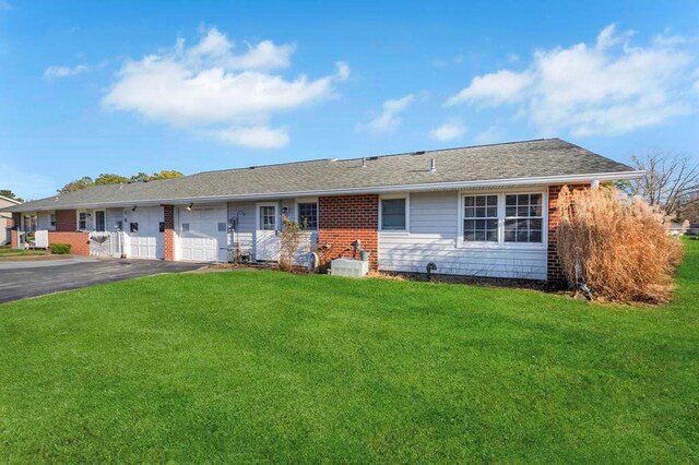 single story home featuring a front lawn and a garage