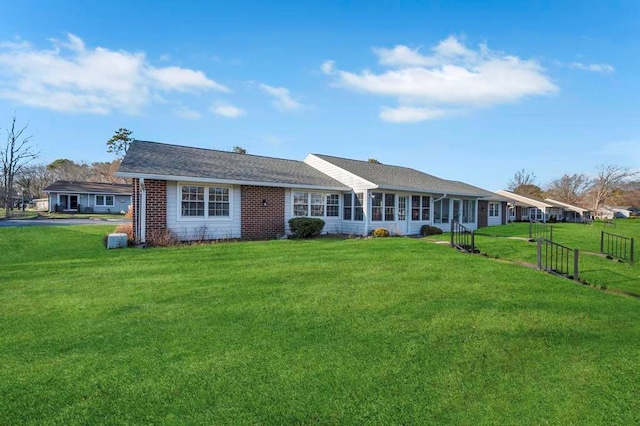 back of house with a yard and a sunroom