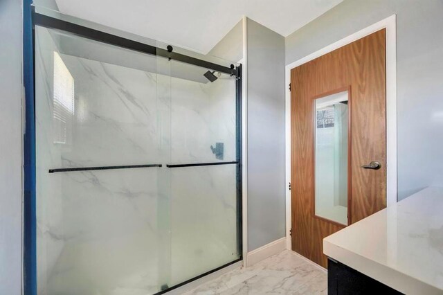 bathroom with vanity, a shower with shower door, and a wealth of natural light