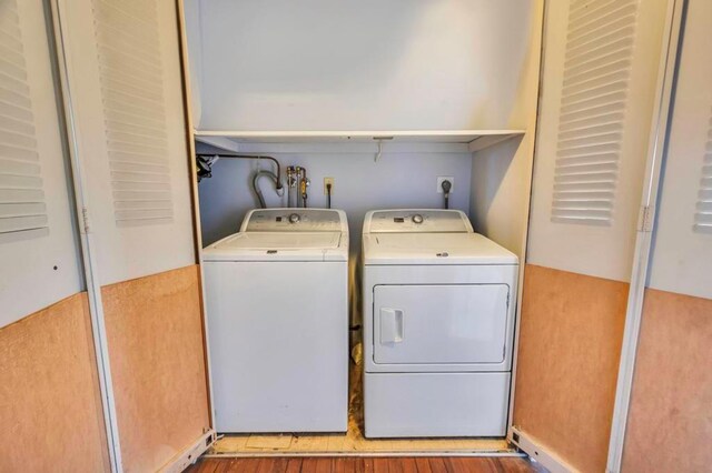 clothes washing area featuring light wood-type flooring and separate washer and dryer