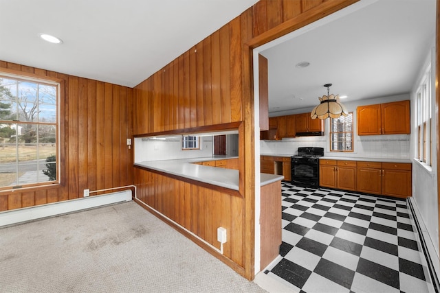 kitchen featuring black gas range, a wealth of natural light, kitchen peninsula, and hanging light fixtures