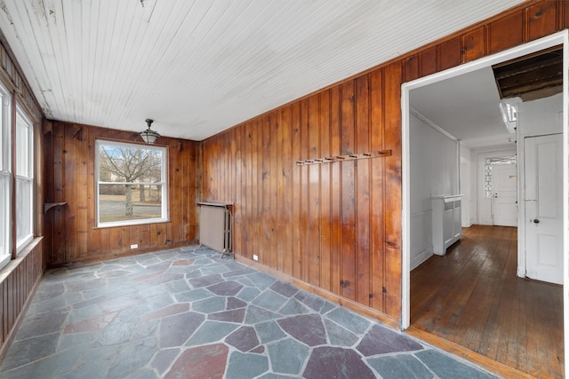 interior space featuring wood walls, ceiling fan, and ornamental molding