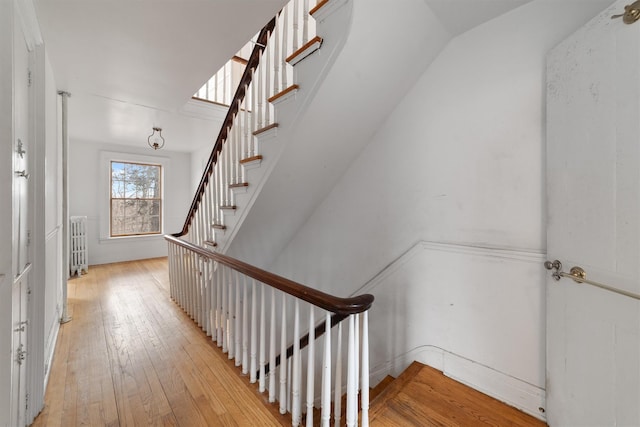 staircase featuring radiator heating unit and hardwood / wood-style floors