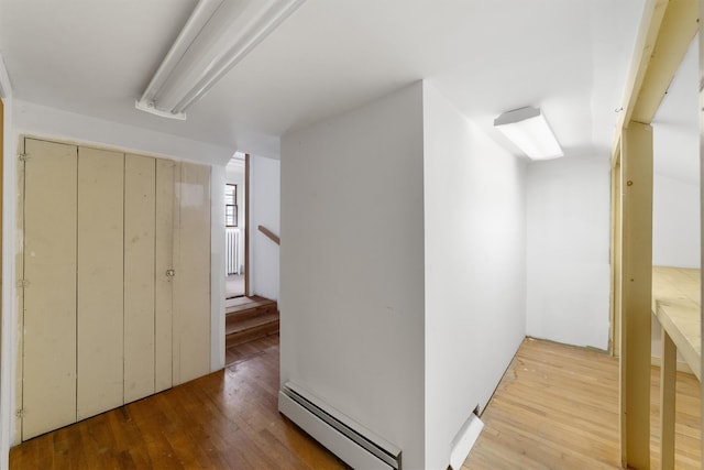 hallway featuring baseboard heating and hardwood / wood-style floors