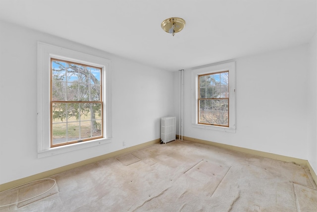 carpeted spare room featuring radiator heating unit