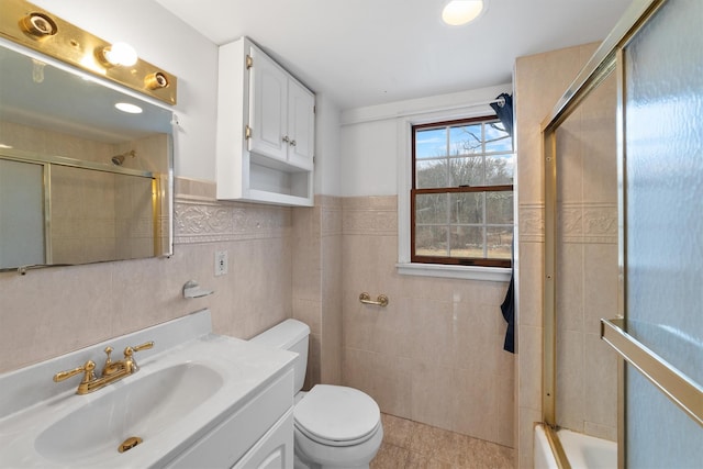 full bathroom with toilet, tile walls, tile patterned floors, enclosed tub / shower combo, and vanity