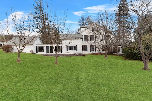 rear view of house featuring a lawn and a sunroom