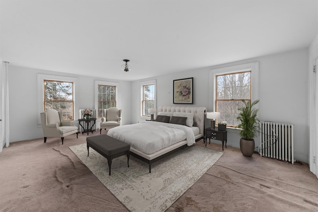 bedroom featuring light carpet, radiator heating unit, and multiple windows