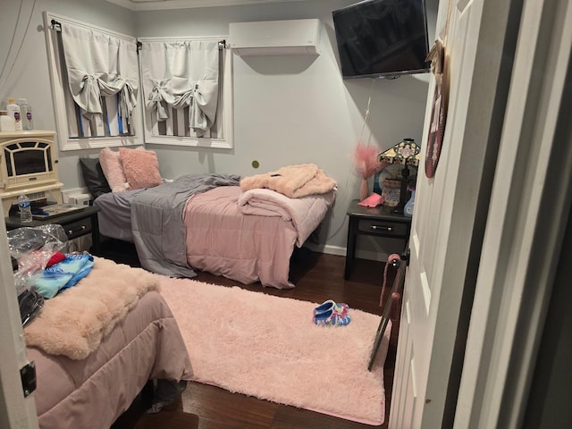 bedroom with dark hardwood / wood-style flooring, crown molding, and a wall mounted air conditioner