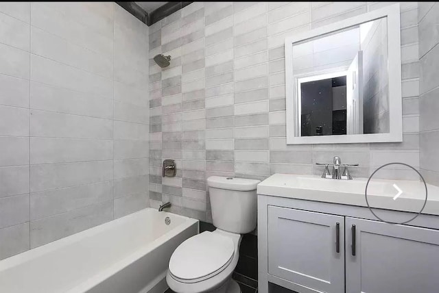 full bathroom with bathtub / shower combination, vanity, toilet, and tile walls