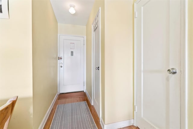 corridor with hardwood / wood-style flooring