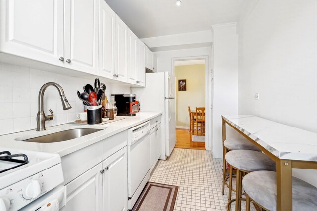 5635 Netherland Ave Unit 4E, Bronx, NY 10471 - kitchen featuring decorative backsplash, sink, white appliances, and white cabinets