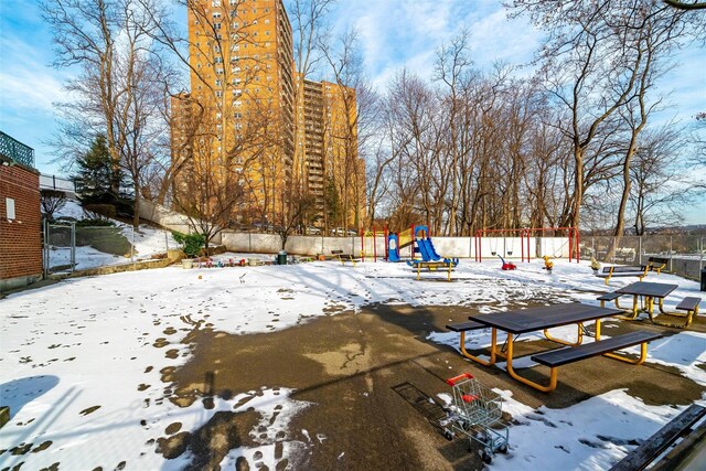 5635 Netherland Ave Unit 4E, Bronx, NY 10471 - yard covered in snow with a playground