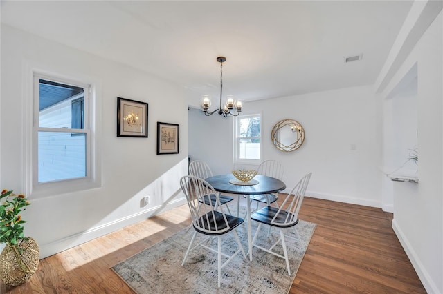 dining space featuring a chandelier and dark wood-type flooring