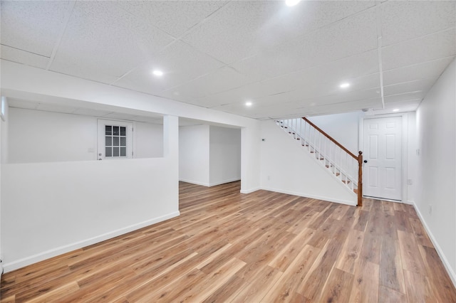 basement with a drop ceiling and hardwood / wood-style flooring