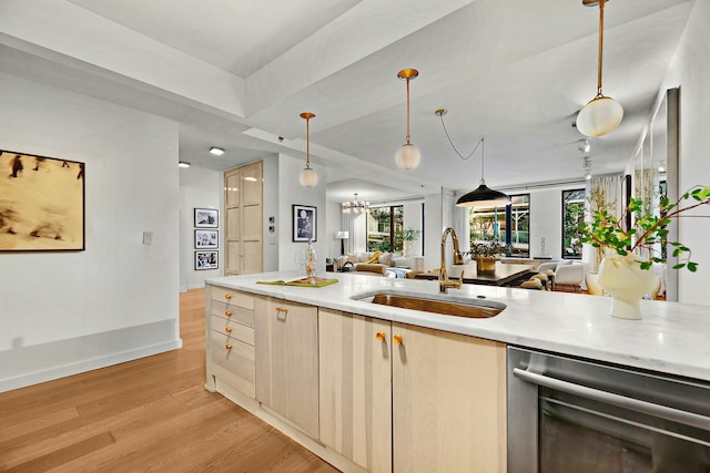 kitchen with sink, hanging light fixtures, stainless steel dishwasher, light hardwood / wood-style floors, and light brown cabinetry