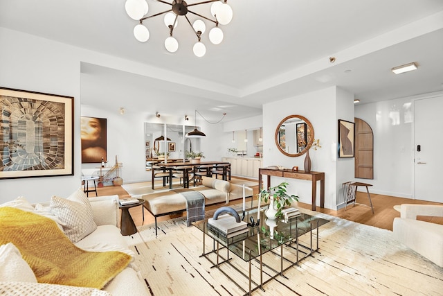 living room with a notable chandelier and light wood-type flooring