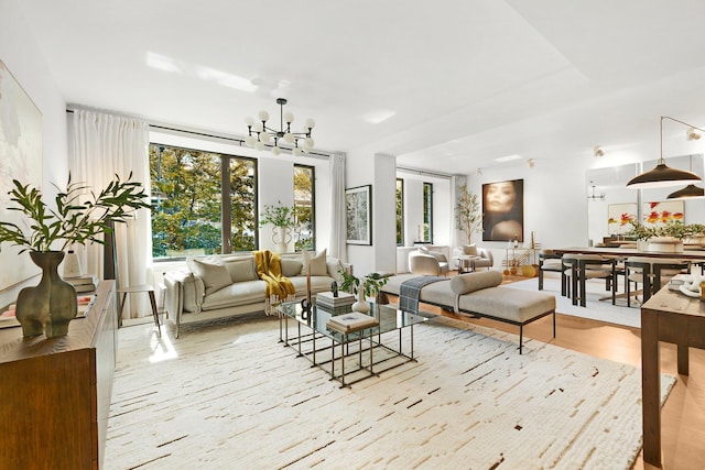 living room featuring light hardwood / wood-style flooring, a wealth of natural light, and an inviting chandelier