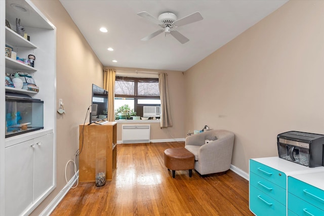 living area featuring hardwood / wood-style flooring and ceiling fan