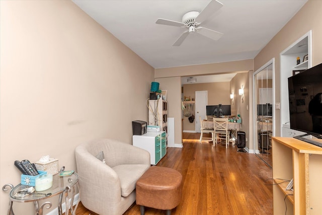 living area with dark hardwood / wood-style flooring and ceiling fan