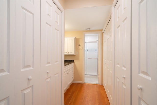 corridor with light hardwood / wood-style flooring