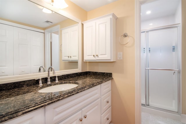 bathroom featuring an enclosed shower, vanity, and tile patterned flooring