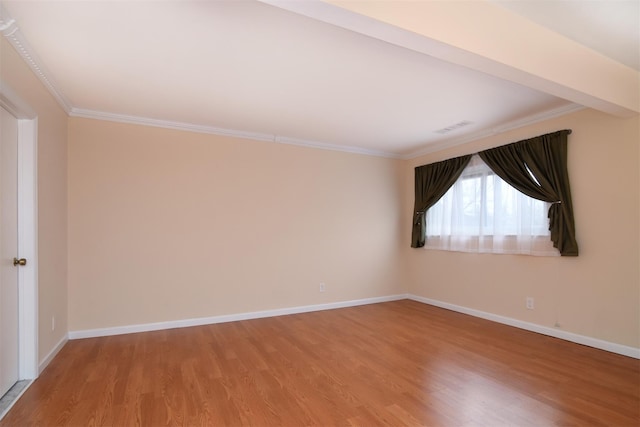 empty room featuring hardwood / wood-style flooring and ornamental molding