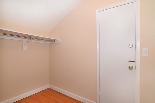 walk in closet with vaulted ceiling and wood-type flooring