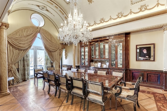 dining area featuring a towering ceiling and an inviting chandelier