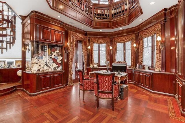 sitting room featuring dark parquet floors, plenty of natural light, and crown molding