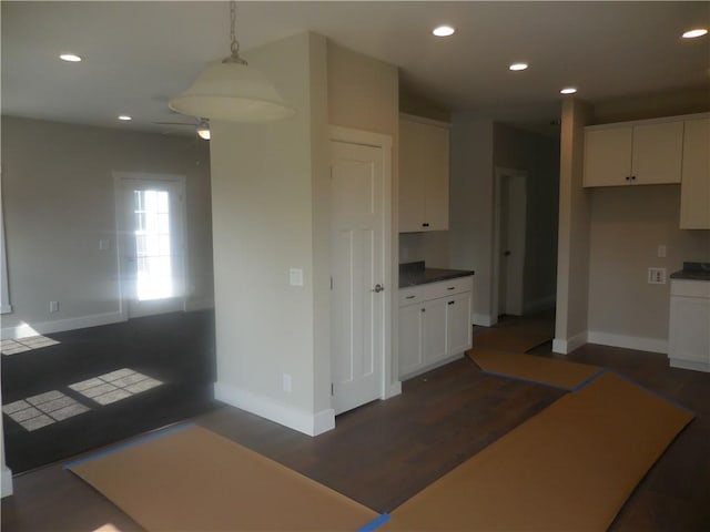 kitchen featuring white cabinets, dark hardwood / wood-style floors, and hanging light fixtures