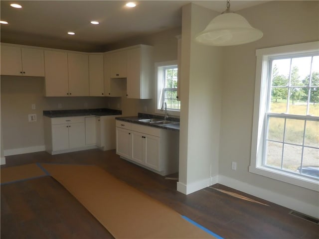 kitchen with white cabinetry, sink, dark hardwood / wood-style floors, and decorative light fixtures