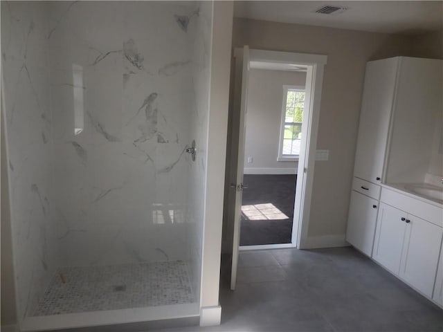 bathroom with vanity and a tile shower