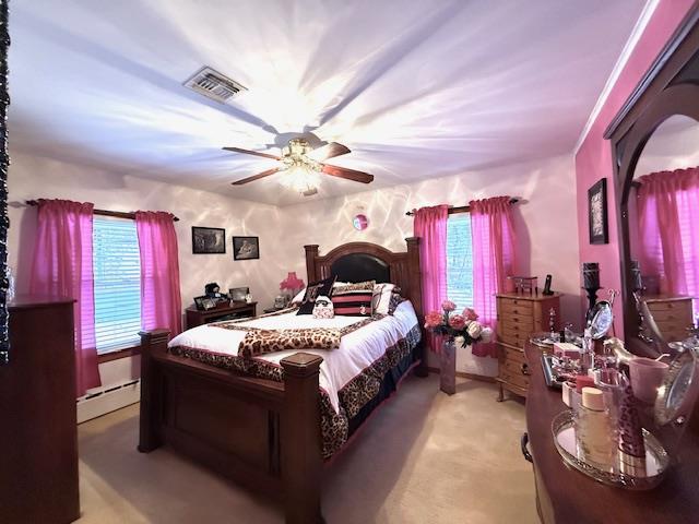 bedroom featuring light colored carpet, ceiling fan, and a baseboard heating unit