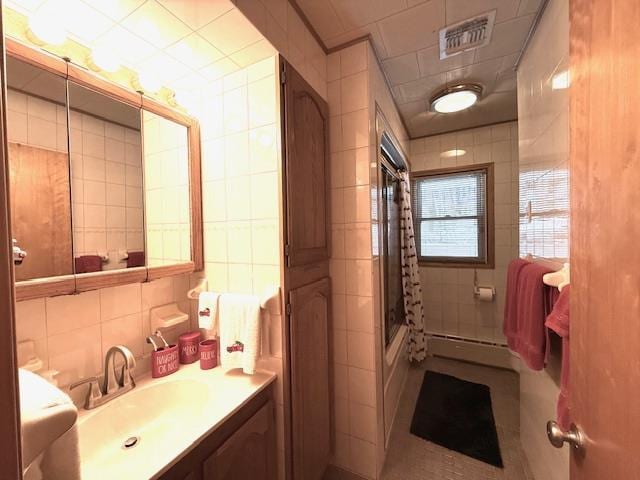 bathroom featuring vanity, bathing tub / shower combination, tile walls, and a baseboard heating unit